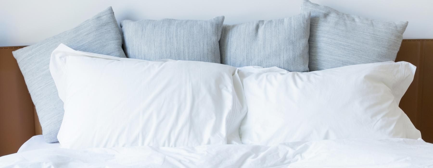 a white bed with pillows
